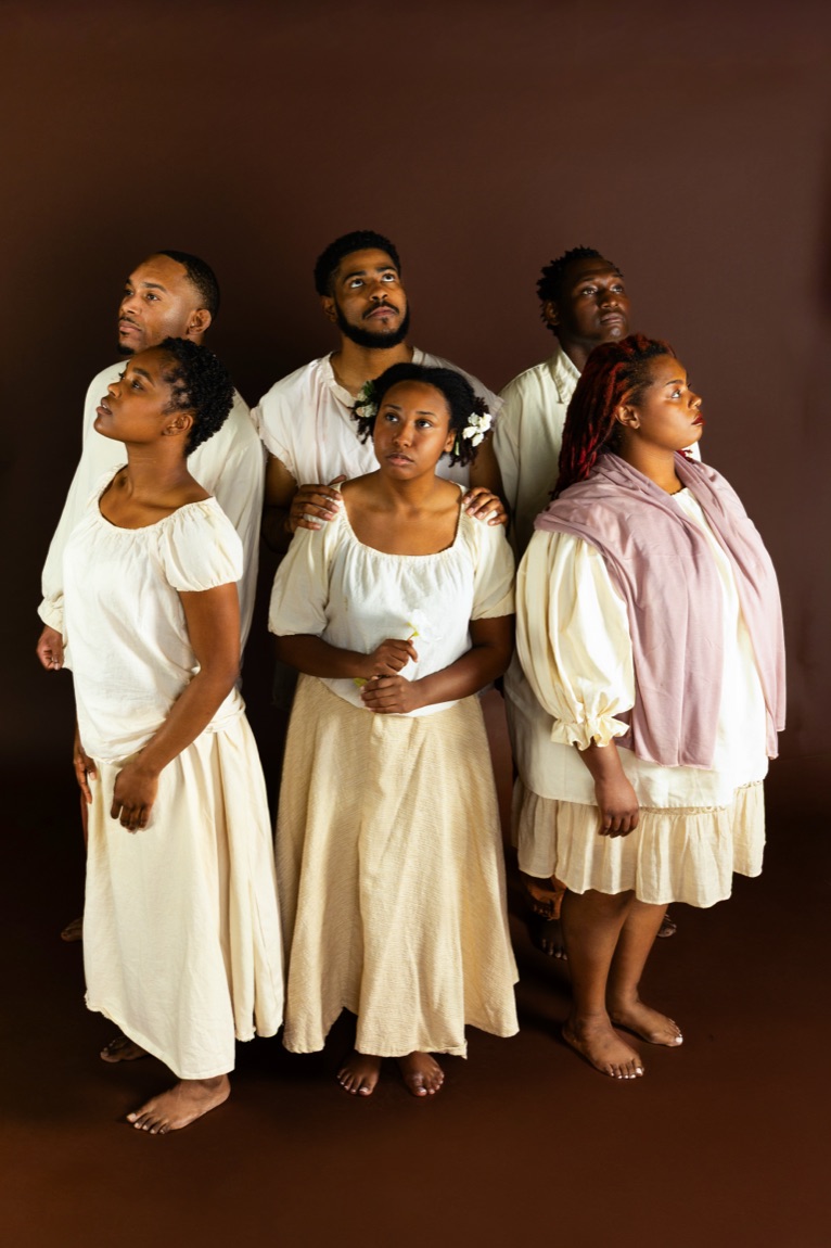 The ensemble in cream dress, gathered and looking upward