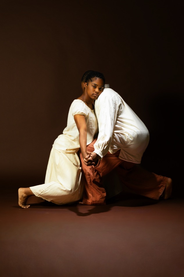 Two performers in a kneeling duet