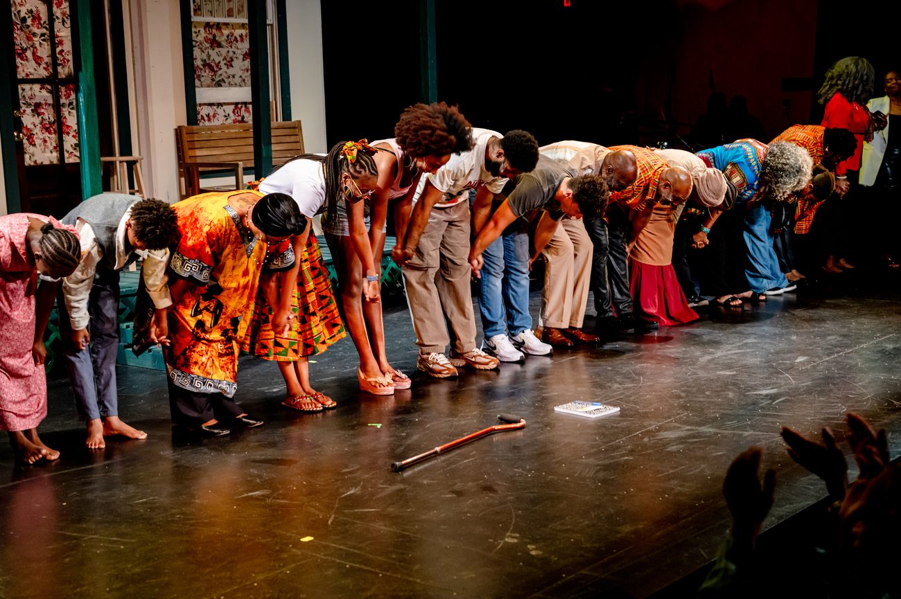 The full company bowing at curtain call as the audience applauds